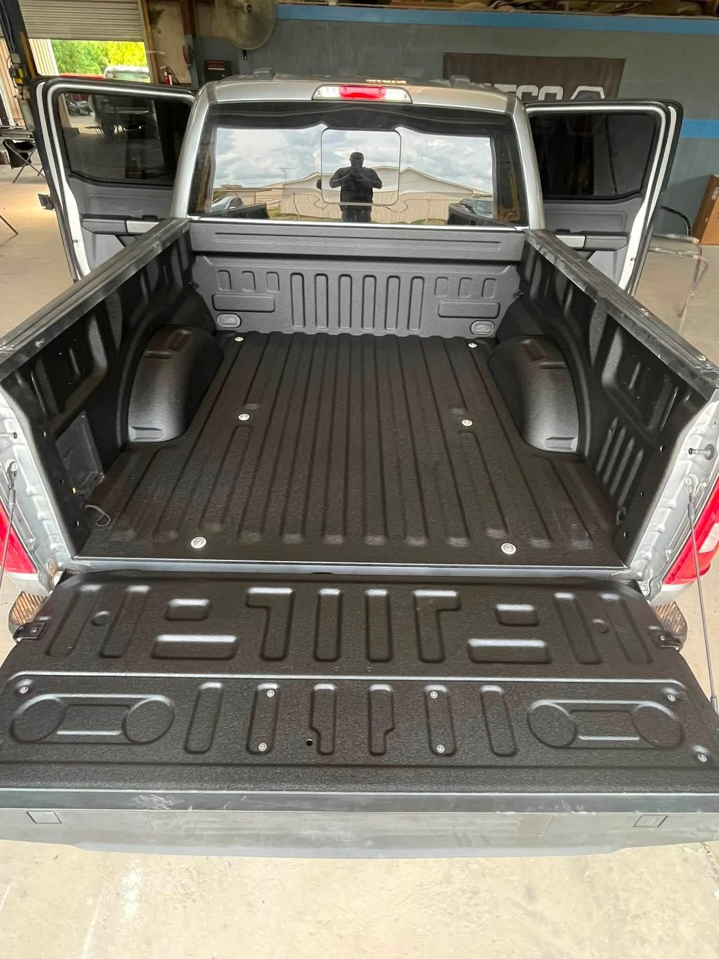 Pickup truck bed coated with a textured black spray-in liner